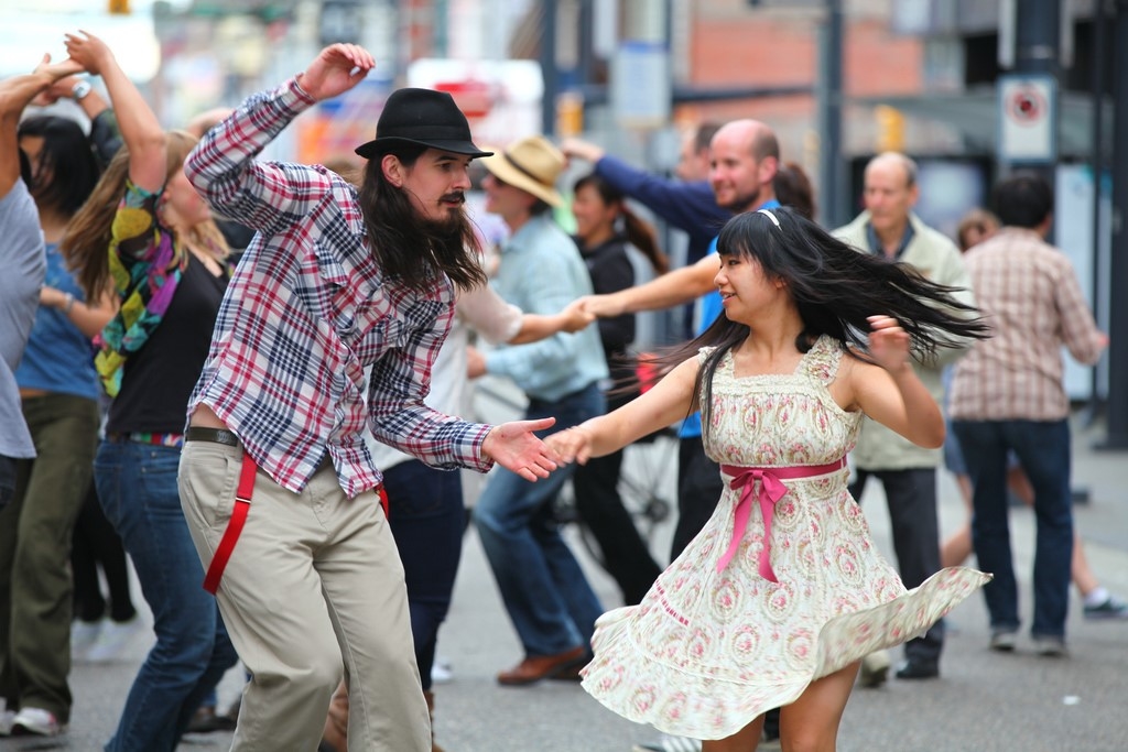 2 personas en las calles bailando canciones de swing